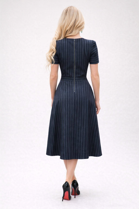 Woman wearing a navy pinstripe dress on a white background