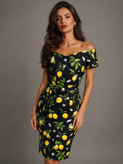 Woman wearing a black dress with lemon print against a gray background