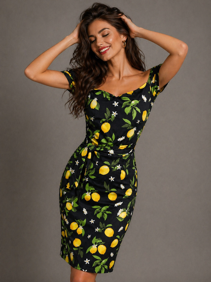Woman wearing a black dress with lemon print against a gray background